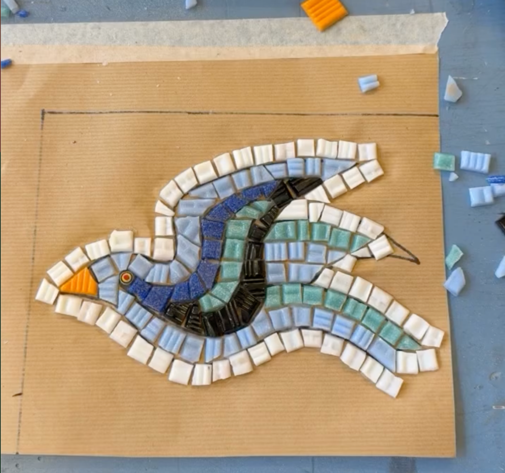 Full view of the bird stencil, with all tiles in place and white tiles outlining the main shape